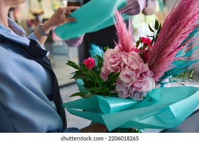 Large flower bouquet in the hands of a florist - Shutterstock ID 2206018265
