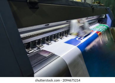 Large format inkjet printer machine working on vinyl paper in workplace - Shutterstock ID 2094675214