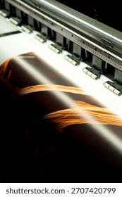 Large format inkjet printer printing colorful graphic on vinyl material in commercial print shop	