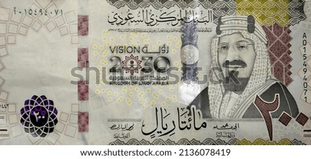 Large fragment of the obverse side of 200 two hundred Saudi riyals banknote features King Abdul Aziz Al Saud the founder of the kingdom and a 3D logo of the nations vision 2030, Saudi Arabia money