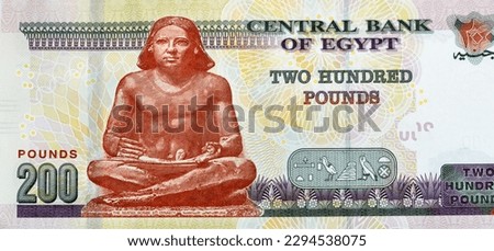 Large fragment of the reverse side of 200 LE EGP two hundred Egyptian pounds cash money banknote paper series 2022 features the seated scribe of ancient Egypt, selective focus of Egyptian money