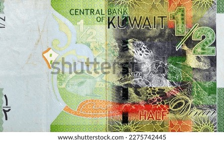 Large fragment of the reverse side of Kuwaiti half dinar green paper banknote cash money bill currency features Hawksbill sea turtle and the silver Pomfret fish (Al Zubadi), selective focus