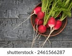 Large fresh radishes in a clay bowl on a wooden table. Healthy and healthy, natural food.