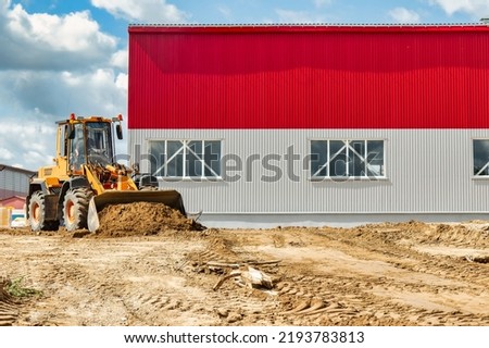 A large front loader pours sand into a pile at a construction site. Transportation of bulk materials. Construction equipment. Bulk cargo transportation. Excavation