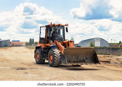 A Large Front Loader Transports Crushed Stone Or Gravel In A Bucket At A Construction Site Or Concrete Plant. Transportation Of Bulk Materials. Construction Equipment. Bulk Cargo Transportation