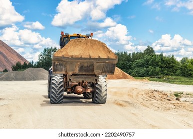 A Large Front Loader Transports Crushed Stone Or Gravel In A Bucket At A Construction Site Or Concrete Plant. Transportation Of Bulk Materials. Construction Equipment. Bulk Cargo Transportation