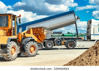 A Large Front Loader Transports Crushed Stone Or Gravel In A Bucket At A Construction Site Or Concrete Plant. Transportation Of Bulk Materials. Construction Equipment. Bulk Cargo Transportation