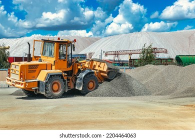 A Large Front Loader Transports Crushed Stone Or Gravel In A Bucket At A Construction Site Or Concrete Plant. Transportation Of Bulk Materials. Construction Equipment. Bulk Cargo Transportation