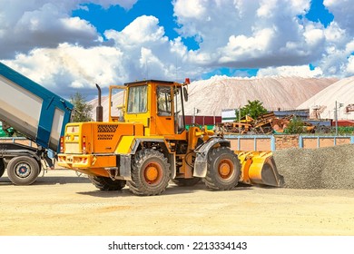 A Large Front Loader Transports Crushed Stone Or Gravel In A Bucket At A Construction Site Or Concrete Plant. Transportation Of Bulk Materials. Construction Equipment. Bulk Cargo Transportation