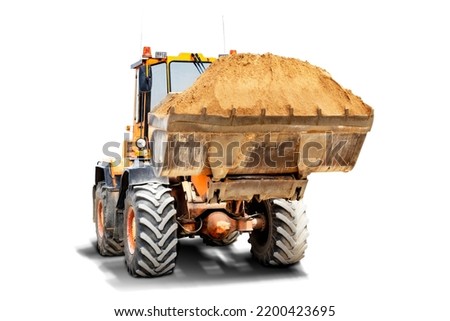 A large front loader transports sand in a bucket at a construction site. Transportation of bulk materials. Isolated loader on a white background