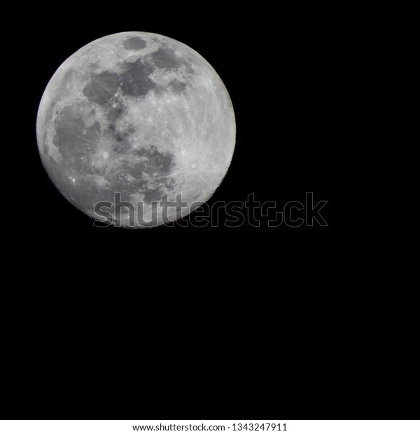 Large full moon, 100% Illumination of lunar\
disk, seen from Eastern Europe, North hemispere, 700 mm focal\
lenght. Copy space for text on square black background. Astronomy,\
astrology, science.