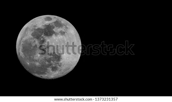 Large full moon, 100% Illumination of lunar\
disk, seen from Eastern Europe, North hemispere, 700 mm focal\
lenght. Copy space for text on right, black wide background.\
Astronomy, astrology,\
science.