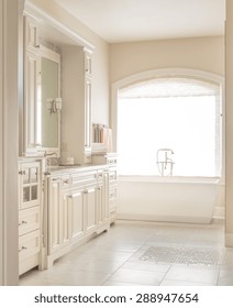 Large Furnished Bathroom In Luxury Home With Tile Floor, Fancy Cabinets, Large Mirror, And Bathtub