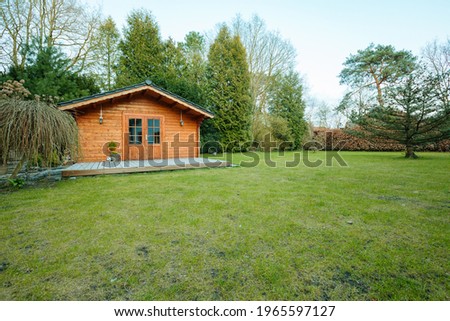 Large garden with green lawn and a wooden garden shed.  [[stock_photo]] © 