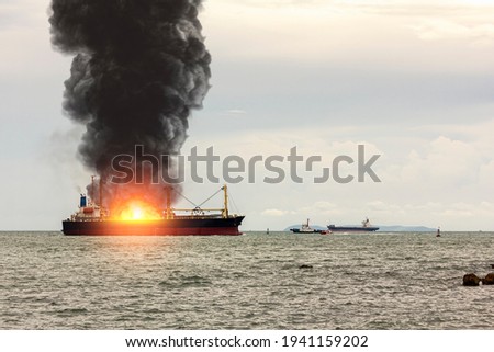 Large general cargo ship for logistic import export goods and other the explosion and had a lot of fire and smoke at sea