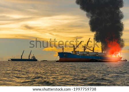 Large general cargo ship for logistic import export goods and other the explosion and had a lot of fire and smoke at sea in evening