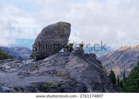 Large glacial erratic boulder perched on a volcanic ridge overlooking the valley, Lassen Volcanic National Park, California, USA