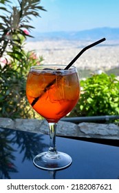 Large Glass Of Aperol Spritz Drink With Ice And A Straw In A Mountain Top Bar. No People.