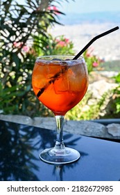 Large Glass Of Aperol Spritz Drink With Ice And A Straw In A Mountain Top Bar. No People.