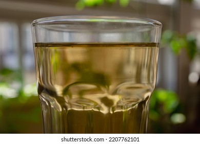 A Large Glass Glass With Green Tea In A Warm Home Environment.