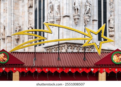 Large golden shooting star decoration is displayed above festive holiday market stalls. Market is set against backdrop of ornate historical building, creating charming holiday scene in city - Powered by Shutterstock