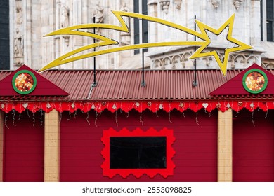 Large golden shooting star decoration is displayed above festive holiday market stalls. Market is set against the backdrop of ornate historical building, creating charming holiday scene in city - Powered by Shutterstock