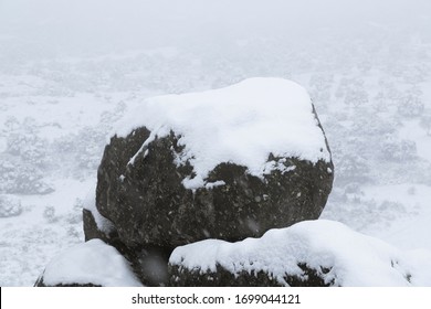 Large Granite Rock Covered By Snow.