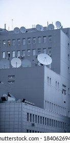 Large Gray Building With Fiberglass Windows, Air Conditioning And Satellite Dishes.