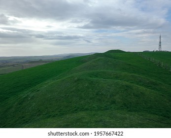 The Large Green Burial Mounds Under A Cloudy Sky In Weymouth, Dorset, UK