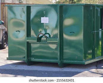 A large green dumpster sitting outside a building with the sign free on it.