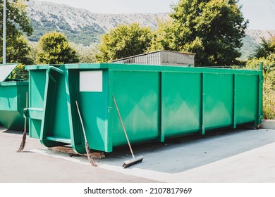 Large green garbage container at local waste sorting station.