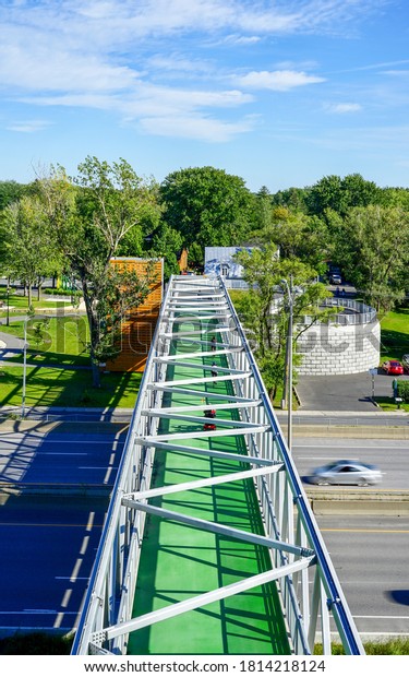Large green metal walkway for cyclists and
pedestrians over the highway, metal railings, people on the bridge,
summer,Longueuil, Quebec,
Canada