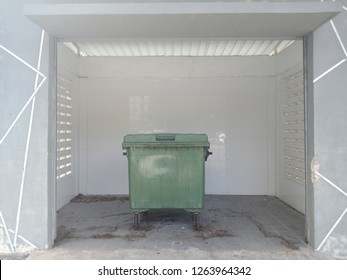 Large Green Plastic Garbage Bin Inside White Building.