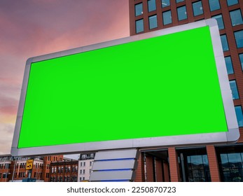 Large Green Screen Advertising Board - City Street scene showing high street and transport hub with billboard for targeted ads towards commuters and shoppers - Powered by Shutterstock