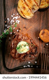 Large Grilled Filet Mignon Steak With Butter And Thyme Served On A Wooden Board. Grilled Meat Dish With Vegetables Top View