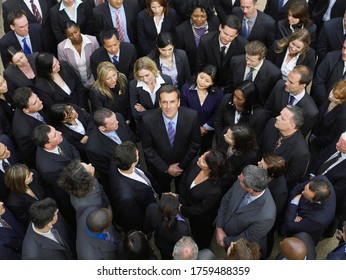 Large group of business people surrounding man looking up elevated view
