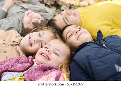 Large Group Of Children. Happy Children Lying On Falling Leaves.