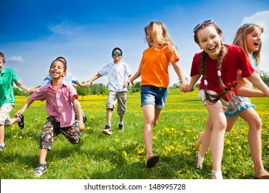 Large group of children running in the dandelion spring field - Shutterstock ID 148995728