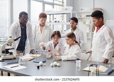 Large group of diverse children wearing lab coats in chemistry class while enjoying science experiments - Shutterstock ID 2137624695