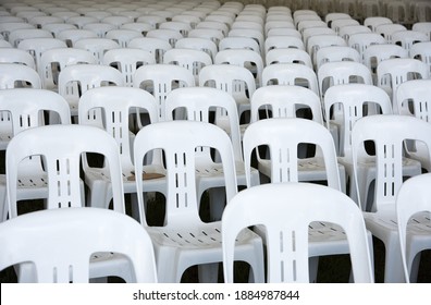 Large Group Of Empty White, Plastic Chairs Lined Up In Rows For Outdoor Event.