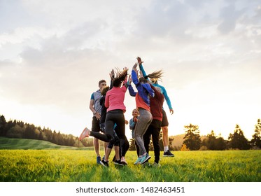 Large group of fit and active people jumping after doing exercise in nature. - Powered by Shutterstock