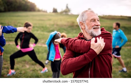 Large group fit   active people doing exercise in nature  stretching 