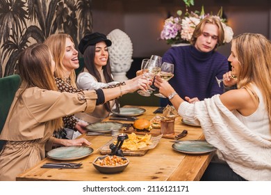 Large Group Of Friends Raising Their Glasses For A Toast At A Dinner Party