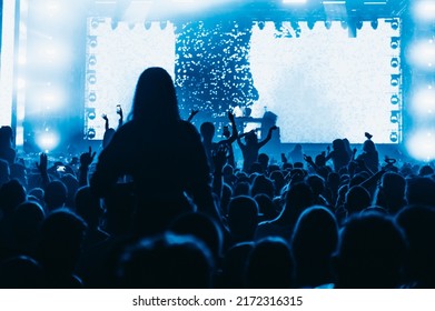 Large Group Of Happy People Enjoying Rock Concert And Clapping With Raised Up Hands. Hands Up With Pleasure From The Show. Music Festival.