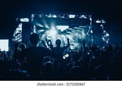 Large Group Of Happy People Enjoying Rock Concert And Clapping With Raised Up Hands. Hands Up With Pleasure From The Show. Music Festival.