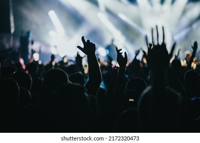 Large Group Of Happy People Enjoying Rock Concert And Clapping With Raised Up Hands. Hands Up With Pleasure From The Show. Music Festival.