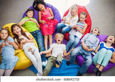 Large Group Of Happy Smiling Kids Sitting Together And Playing Indoor