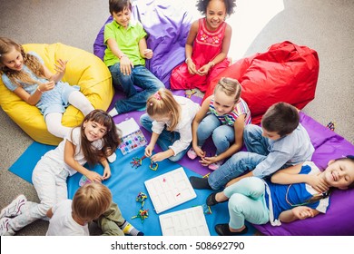 Large Group Of Happy Smiling Kids Sitting Together And Playing Indoor