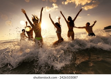 Large group of happy young friends of tourists are having fun, runs and jumps at sunset sea beach. Tropical weekend concept - Powered by Shutterstock