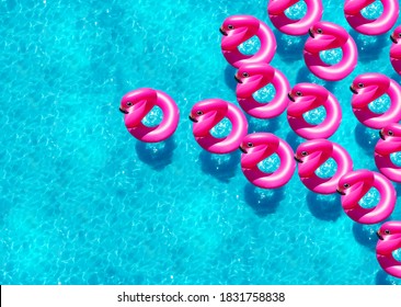 Large Group Of Inflatable Flamingo Buoy Swim In The Swimming Pool View From Above